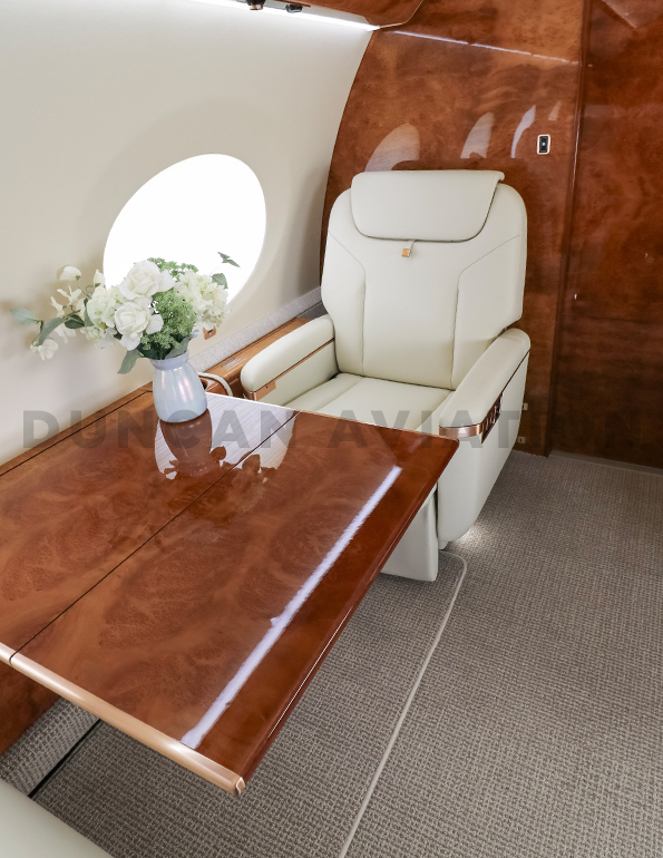 Cream leather captain chair and retractable table inside refurbished Gulfstream 650