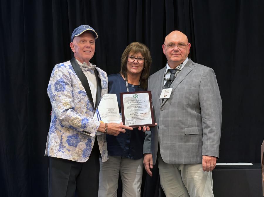 Joe Tulowitzki stands with his wife and an FAA member as he holds his Charles Taylor award certificate